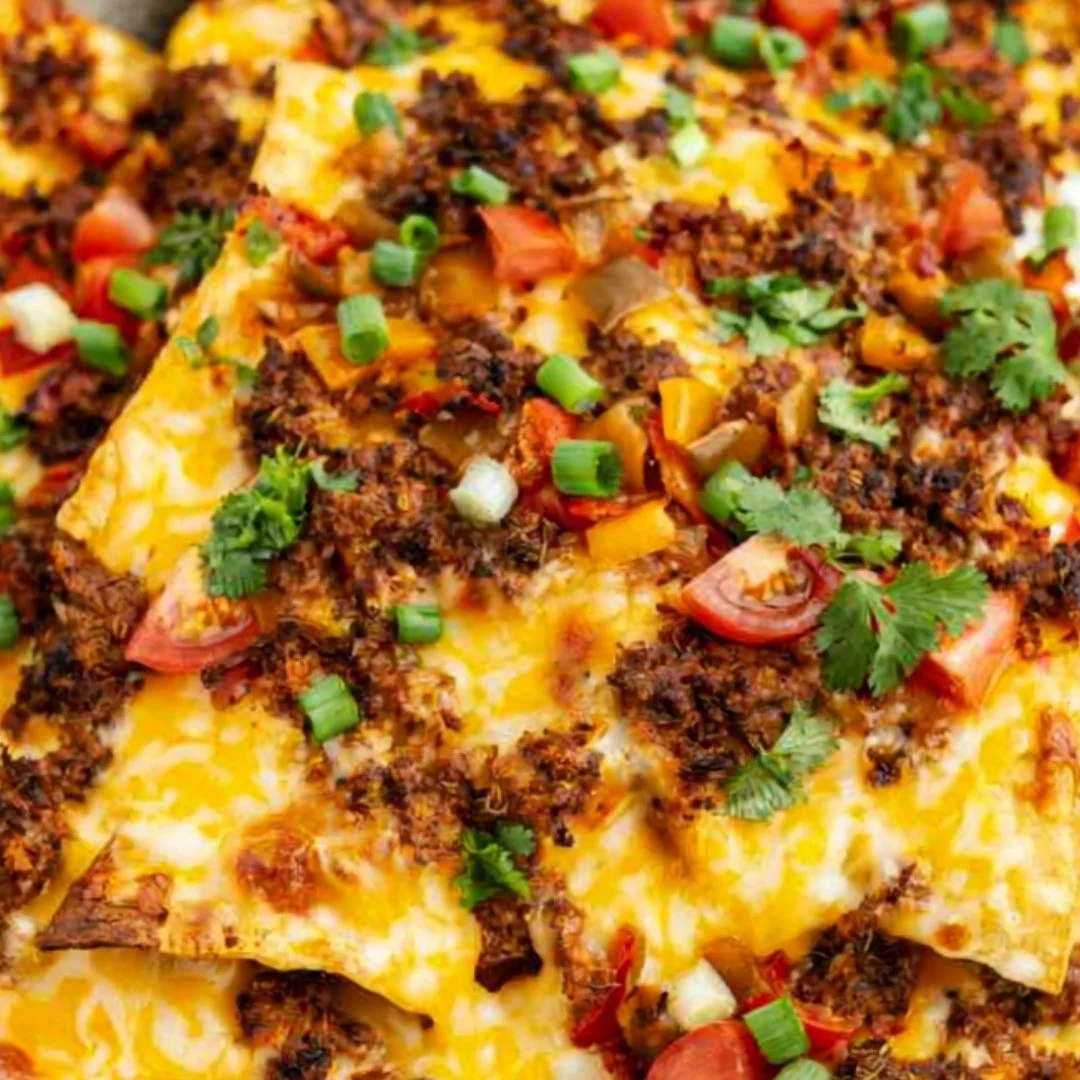 Cozy air fryer nachos topped with cheese, jalapenos, and guacamole